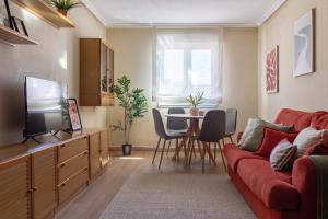 a living room with a red couch and a table at AH El Corazón de Corrida VUT4786AS in Gijón