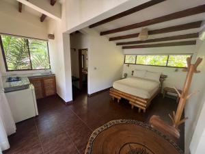 una camera con letto e una cucina con finestre di Spondylus Lodge ad Ayampe