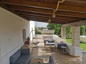 a patio with couches and chairs and a table at Villa a Serranova, Torre Guaceto in Carovigno