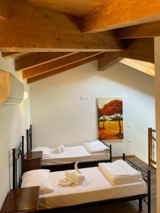Habitación con 3 camas y una pintura en la pared. en Residenza Le Due Torri, en Riva del Garda