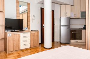 a kitchen with wooden cabinets and a refrigerator at Bobo Apartment in Budva
