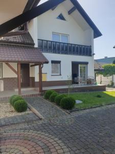 a large white house with a brick driveway at Queen Jadwiga's Apartment in Busko-Zdrój