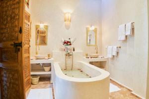 ein weißes Badezimmer mit zwei Waschbecken und einer Badewanne in der Unterkunft DAR SOHAN Kasbah vue mer in Tangier