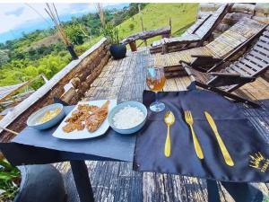 una mesa con platos de comida, tenedores y cucharas en Vibras Eco Hotel en Popayán