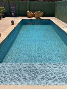 einen Pool mit blauen Bodenfliesen in der Unterkunft Chalet villa familiale in Imouzzer du Kandar