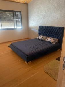 ein Schlafzimmer mit einem Bett in einem Zimmer mit einem Fenster in der Unterkunft Chalet villa familiale in Imouzzer du Kandar