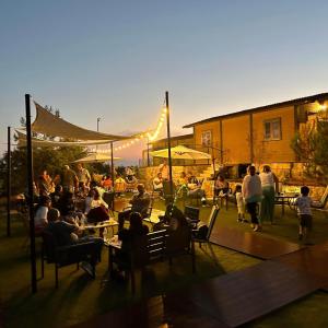 Un grupo de personas sentadas en mesas en un patio. en Casa del mir, en Dayr al Qamar