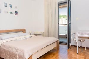 1 dormitorio con cama, mesa y balcón en Bobo Apartment en Budva