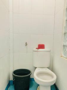 een badkamer met een wit toilet en een zwarte emmer bij SEUNIA HOTEL in Lamnyong