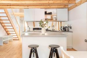 a kitchen with white cabinets and a counter with stools at Sofija's Central Apartments in Ljubljana