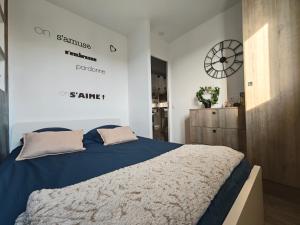 a bedroom with a bed and a clock on the wall at Au jardin suspendu in Vanves