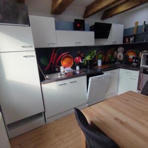 a kitchen with white cabinets and a sink and a table at Zum alten Schmied Vermietung und Verpachtung Schönfeld 