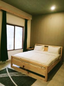 duże łóżko w pokoju z dużym oknem w obiekcie BONO MOTELS w mieście Naran