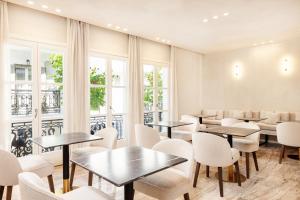 un restaurant avec des tables, des chaises et des fenêtres dans l'établissement Doryssa Method Hotel, à Pythagoreio