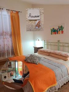 1 dormitorio con 1 cama con manta naranja en Affittacamere Albafiorita en Castiglione dʼOrcia