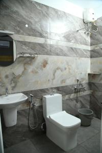 a bathroom with a white toilet and a sink at 88 homes kochi in Ernakulam