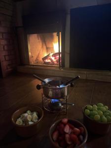 a stove with three bowls of vegetables and a fire at Chalé da Sorte in Gonçalves +46 photos