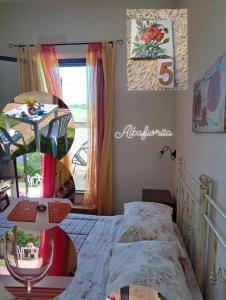 sypialnia z łóżkiem, stołem i oknem w obiekcie Affittacamere Albafiorita w mieście Castiglione dʼOrcia