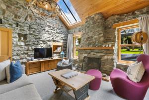 a living room with a stone wall at Judge & Jury Farm Retreat in Gibbston