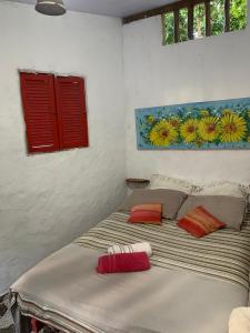 a bedroom with a bed with two pillows on it at Conjunto Sol Roots in Pipa