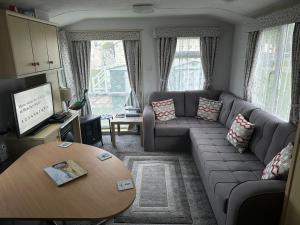 a living room with a couch and a table at Esmeralda's Caravan Hire Mablethorpe in Mablethorpe