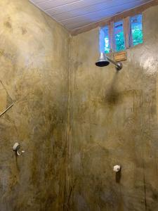a shower with a stone wall with a light on it at Conjunto Sol Roots in Pipa +32 photos