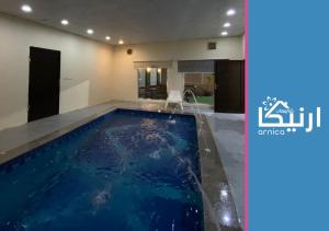 a swimming pool in a house with a water fountain at شالية ارنيكا in As Sayl aş Şaghīr