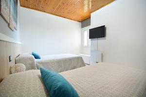 una camera con 2 letti e una TV a schermo piatto di Apartamento con vistas en Pedras Negras a Pontevedra