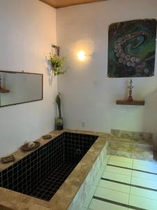 een kamer met een zwarte tegelvloer en een schilderij bij Conjunto Sol Roots in Pipa