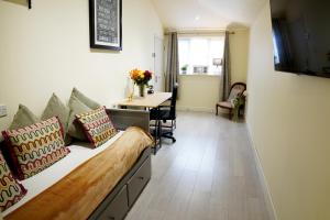 a room with a couch and a table in a room at CRHeathrow in Stanwell
