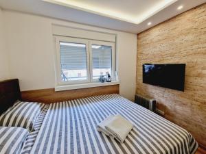 een slaapkamer met 2 bedden en een flatscreen-tv bij Verona 25 in Vrnjačka Banja