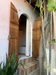 een kamer met een houten deur en trap bij Conjunto Sol Roots in Pipa