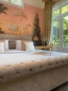 uma cama grande num quarto com paredes cor-de-rosa em Penarwyn House em Par