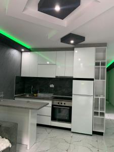 a kitchen with white appliances and a green light at Zlatna plaža in Bratunac