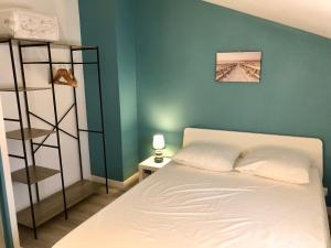 a bedroom with a white bed and a green wall at Maison rénovée à 300m de la mer in Saint-Hilaire-de-Riez