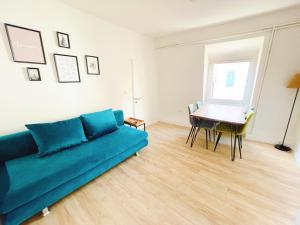 een woonkamer met een blauwe bank en een tafel bij StayHere Central City Suite 11 - contactless Self-Check-IN in Graz