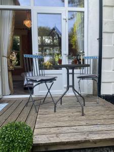 einen Tisch und zwei Stühle auf einer Veranda in der Unterkunft Penarwyn House in Par