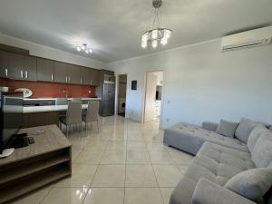 a living room with a couch and a kitchen at Elpida Luxury Apartments Suites in Nydri