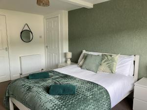 een slaapkamer met een groot bed met 2 groene kussens bij River View in Hawick