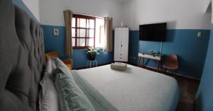 Un dormitorio con una cama con paredes azules y una ventana en Miraflores Kennedy Park, en Lima