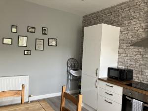 a kitchen with a white cabinet and a microwave at River View in Hawick