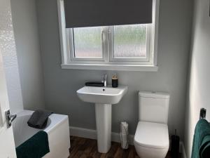 een badkamer met een wastafel, een toilet en een raam bij River View in Hawick