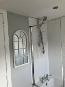 uma casa de banho com um chuveiro, um lavatório e uma janela em River View em Hawick