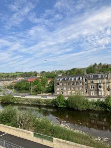 een gebouw naast een rivier naast een gebouw bij River View in Hawick