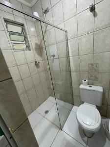 a bathroom with a toilet and a glass shower at Hotel Puma in Sao Paulo