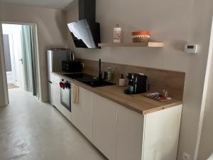 a kitchen with white cabinets and a counter top at Maison Mirabeau in Arles