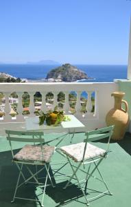 einen Tisch und zwei Stühle auf einem Balkon mit Meerblick in der Unterkunft Villa Eleonora, un angolo di Paradiso ad Ischia in Ischia