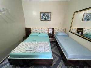 2 Betten in einem Zimmer mit Spiegel in der Unterkunft Hotel Puma in São Paulo