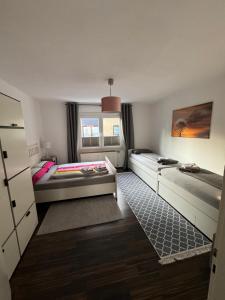 a small room with two beds and a window at Sana Ferienwohnung in Oberhausen