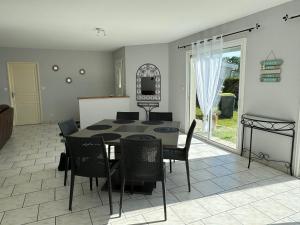 - une salle à manger avec une table et des chaises dans l'établissement Jolie maison avec jardin proche bordeaux et océan, à La Brède